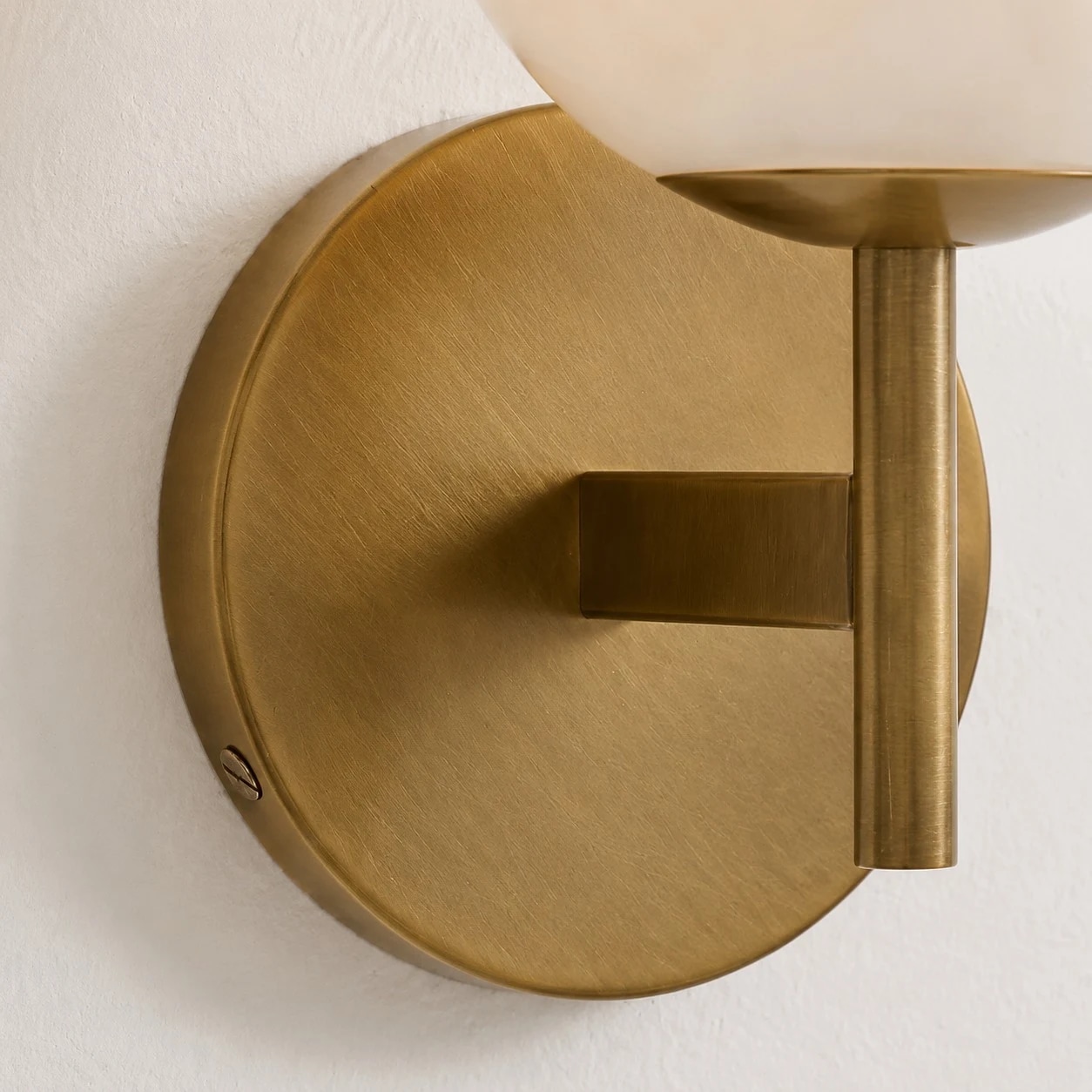 Close detail of brass round canopy and wall arm
